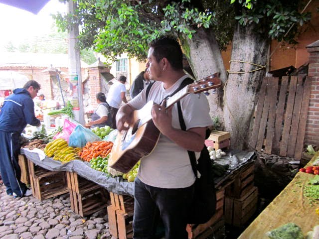 Man Playing his Guitar at the Market