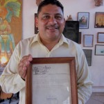 Owner, Hector holding the First Invitation to Manix