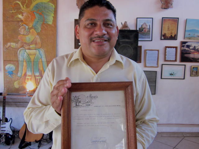 Owner, Hector holding the First Invitation to Manix